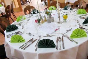ビュッケブルクにあるJetenburger Hofの白いテーブル(緑のナプキンと銀器付)