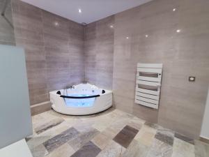 a bathroom with a tub in the corner of a room at Entre mer et campagne in Saint-Martin-de-Seignanx