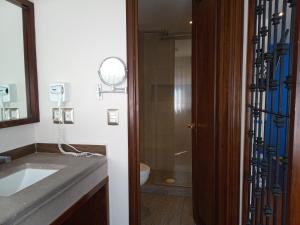 a bathroom with a sink and a toilet and a mirror at Hotel Alameda Centro Historico in Morelia +35 photos