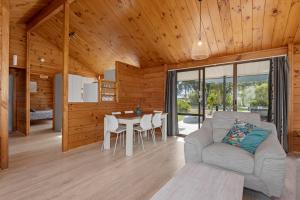 un soggiorno con divano e tavolo di Bream Bay Sands - Ruakaka Holiday Home a Ruakaka