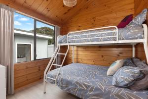 En eller flere køyesenger på et rom på Bream Bay Sands - Ruakaka Holiday Home