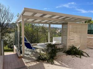 einem Pavillon mit einem Stuhl und einer Hängematte darunter in der Unterkunft Il parco di Yuki (5) in Ancona