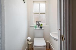 Un baño blanco con inodoro y ventana. en Spacious Contractor House for Large Groups - Private Parking, en Northampton 18 fotos más