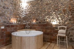 a bathroom with a wooden tub in a brick wall at GardaBeds Adults Only in Castelnuovo del Garda