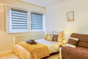een slaapkamer met een bed en een bank bij AlsaceTime, CENTRE Parking gratuit, TRAM WIFI, Fibre Orange, espace de travail in Straatsburg