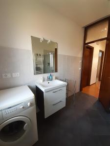ein Badezimmer mit einer Waschmaschine und einem Waschbecken in der Unterkunft Casa Vacanze Riviera del Brenta in Dolo
