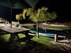 a table with an umbrella next to a swimming pool at Mariri Heights Tasman in Upper Moutere