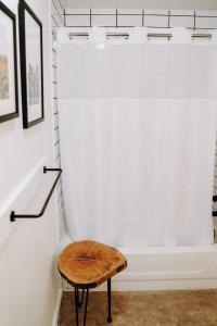a wooden stool in front of a bath tub at Wimberley Inn in Wimberley