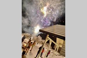 a group of people standing in the snow with fireworks at Mazurski Domek - Wake Up Home Ogonki in Ogonki