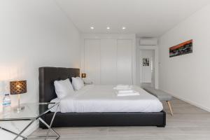 a bedroom with a bed and a glass table at Chill House - Luxury house in Mariquiteira