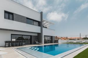 a swimming pool in the backyard of a house at Chill House - Luxury house in Mariquiteira