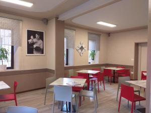 a dining room with tables and red chairs at Locanda la torre in Calvisano