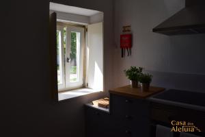 a kitchen with a window and a mirror on the wall at Casa dos Aleluia in Coimbra