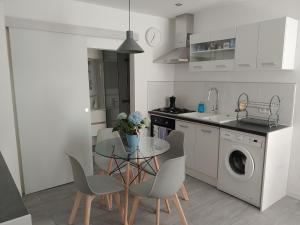 a kitchen with a table and a washing machine at LAN'ApparT in Morez