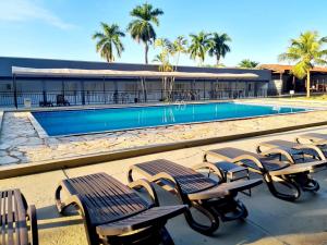une rangée de bancs à côté d'une piscine dans l'établissement HOTEL AGUAS DE BODOQUENA, à Bodoquena