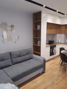 a living room with a couch and a kitchen at Apartament Nadmorskie Tarasy z widokiem na morze in Gdynia