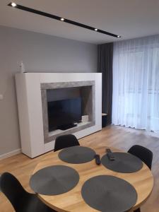 a dining room with a table and chairs and a fireplace at Apartament Nadmorskie Tarasy z widokiem na morze in Gdynia