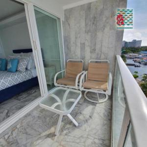 - Balcón con 2 sillas y 1 cama en Hermosos Apartamentos Frente Al Mar, en San Andrés