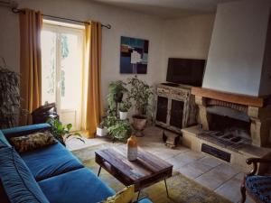 a living room with a blue couch and a fireplace at La Dolce Vita - Chambre Cristoforo Colombo in Montpeyroux