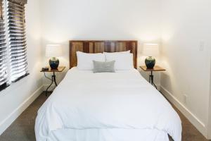 a white bed with a white comforter and pillows at Sonoma's Best Guest Cottages in Sonoma