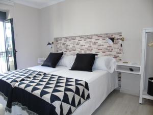 a bedroom with a large bed with a brick wall at Casa San Nicolás in Portomarin