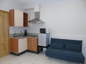 a living room with a couch and a kitchen at Casa San Nicolás in Portomarin