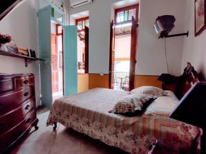 a bedroom with a bed and a dresser and windows at Rio Antigo in Rio de Janeiro