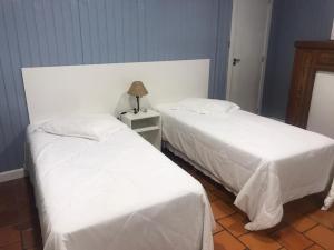 two beds sitting next to each other in a room at Apartamentos Sulla Collina Centro de Gramado localizado próximo da rua Coberta in Gramado