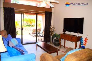 a living room with a blue couch and a tv at Marina Pinacate B-118 in Puerto Peñasco
