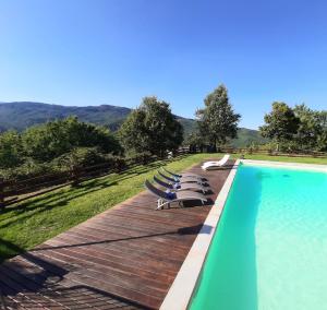 uma piscina com espreguiçadeiras num deque de madeira em Villa Galearpe with private pool in Tuscany em Salutio