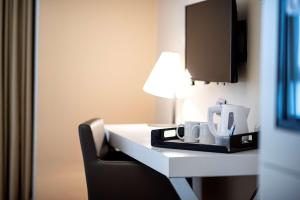 a room with a desk with a lamp and a chair at Best Western Hotel Quattrotorri in Perugia