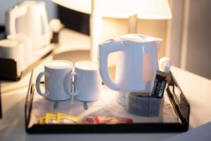 ein Tablett mit zwei Kaffeetassen auf dem Tisch in der Unterkunft Best Western Hotel Quattrotorri in Perugia