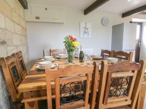 een eettafel en stoelen met een houten tafel en een stoeltje bij Hayloft in Staintondale