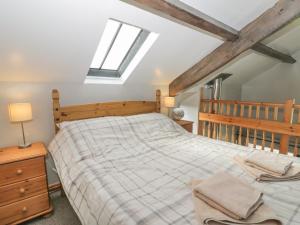 een slaapkamer met een groot bed en 2 ramen bij Hayloft in Staintondale