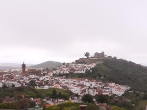 een stad bovenop een heuvel met een kasteel bij Vivienda Rural Olivar del Chanza in Cortegana