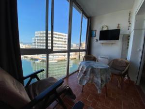 una stanza con tavolo e sedie e una grande finestra di ROSES NAUTIC, estudio loft a 300 m de la playa,vistas espectaculares a Roses