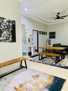 a living room with two benches and a table at Homestay Wan D in Kota Bharu