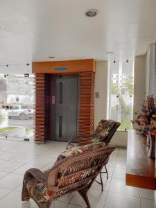 um átrio com um banco de vime num edifício em Principe Hotel em Itabuna
