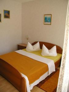 a bedroom with a large bed with white pillows at Rooms Vila Mautner in Vodice