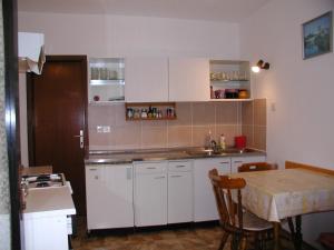 a kitchen with white cabinets and a table with a tableablish at Rooms Vila Mautner in Vodice +64 photos