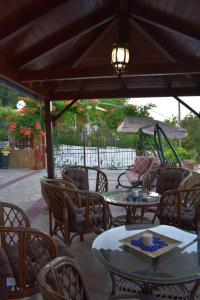 a patio with tables and chairs and a carousel at Mamas Reas in Káto Spílaion