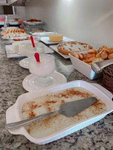 a table topped with plates of food on a counter at Principe Hotel in Itabuna