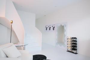 a white room with a white couch and a glass table at Bianca in Tainan