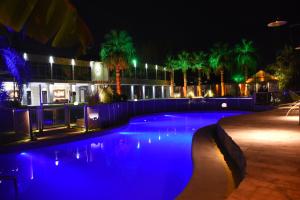 a swimming pool at night with blue lights at Hotel Viñas del Sol in San Juan