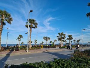 a street with palm trees and the ocean in the background at RESIDENCE LA CORNICH in Nador