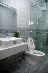 La salle de bains est pourvue de toilettes, d'un lavabo et d'une douche. dans l'établissement Peony Hotel, à Đà Lạt