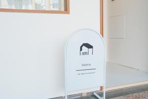 a sign for a hotel against a white wall at Bianca in Tainan
