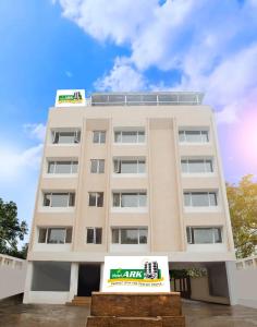 a white building with a sign in front of it at Lee-Benz ARK HOTEL in Kumbakonam