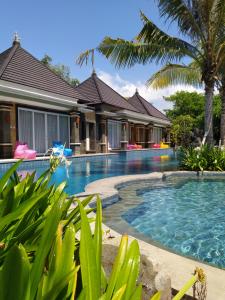 a swimming pool in front of a villa at Kori Maharani Villas & Resort in Keramas