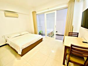 1 dormitorio con cama, escritorio y ventana en Pearl Service Apartment, en Ho Chi Minh
